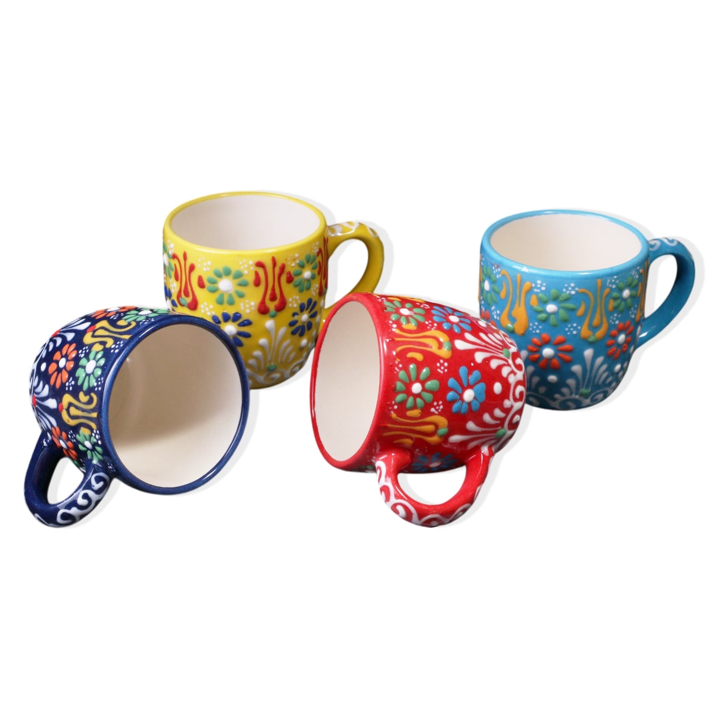 A set of four ceramic espresso cups in various colors, each with a unique floral pattern.