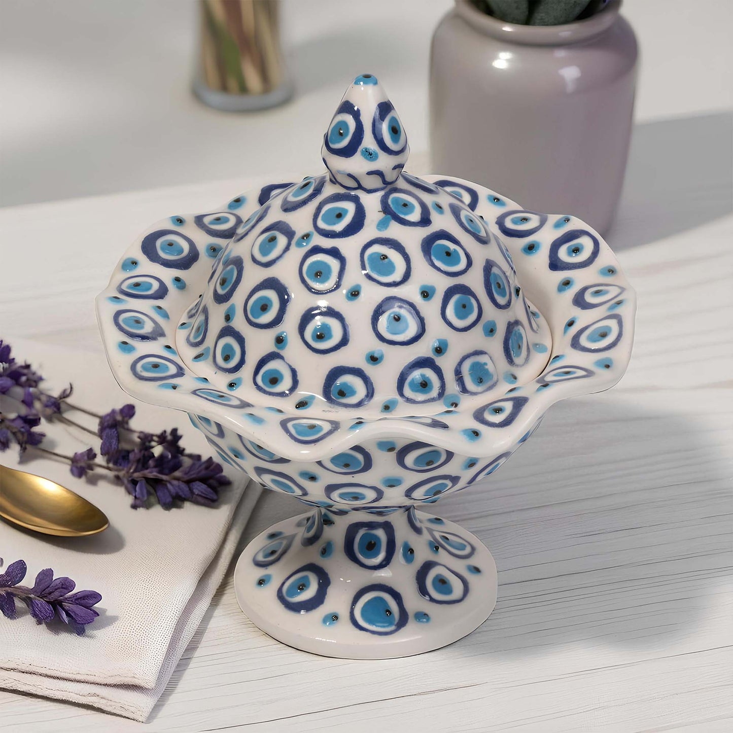 Ceramic sugar bowl with blue and white pattern on a light wooden surface with lavender and a spoon.