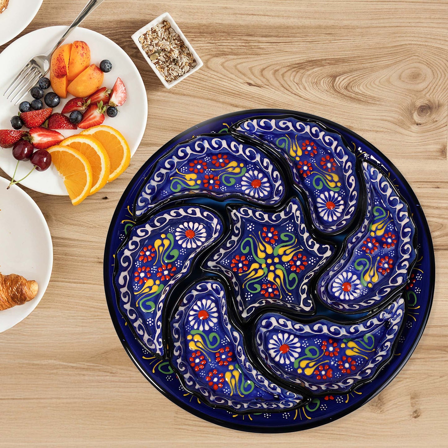 Decorative snack serving tray set with colorful paisley design on a wooden table with breakfast items.
