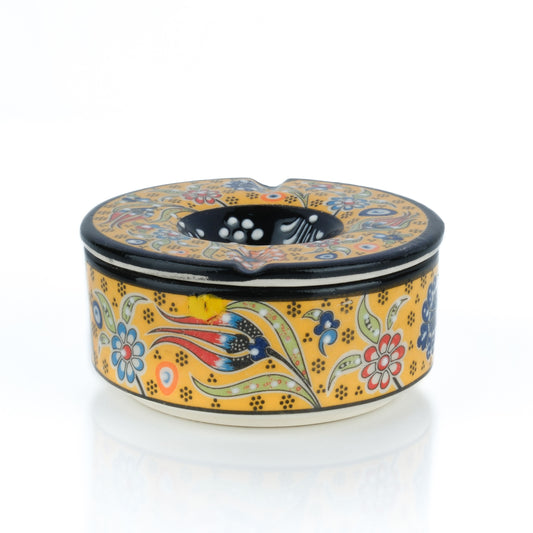 A handmade ceramic ashtray with a colorful floral pattern and a lid.