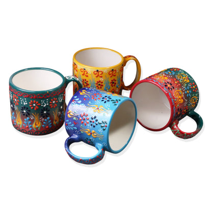 A set of four ceramic espresso cups in various colors, each with a unique floral and paisley pattern.