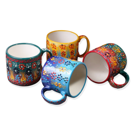 A set of four ceramic espresso cups in various colors, each with a unique floral and paisley pattern.