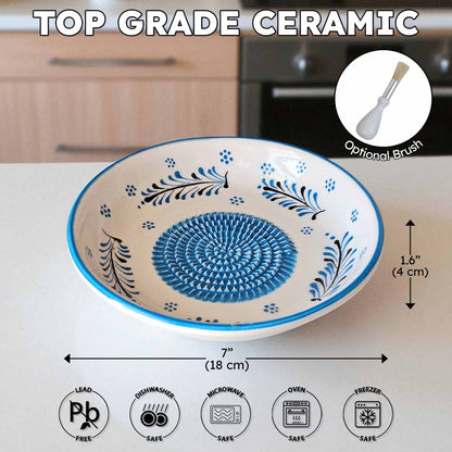 Ceramic garlic grater bowl with blue floral patterns on a kitchen counter, featuring dimensions and safety icons.