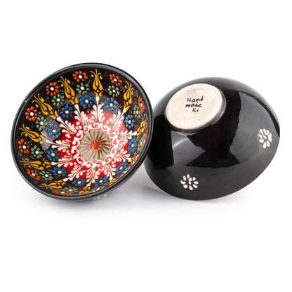 Decorative black ceramic cereal bowl with colorful floral design on a white background