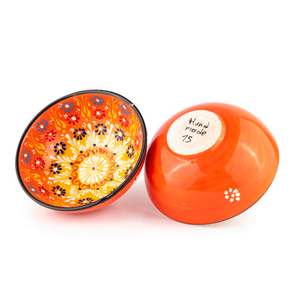 Two orange ceramic salad bowls with decorative patterns on a white background