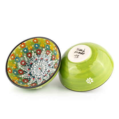 Two ceramic cereal bowls, one with floral design and one green with white flower pattern, on a white background.