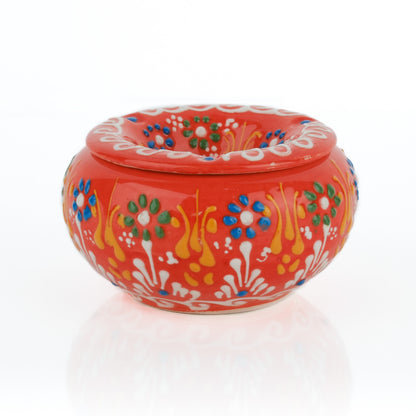 Decorative red ashtray with colorful floral patterns on a white background