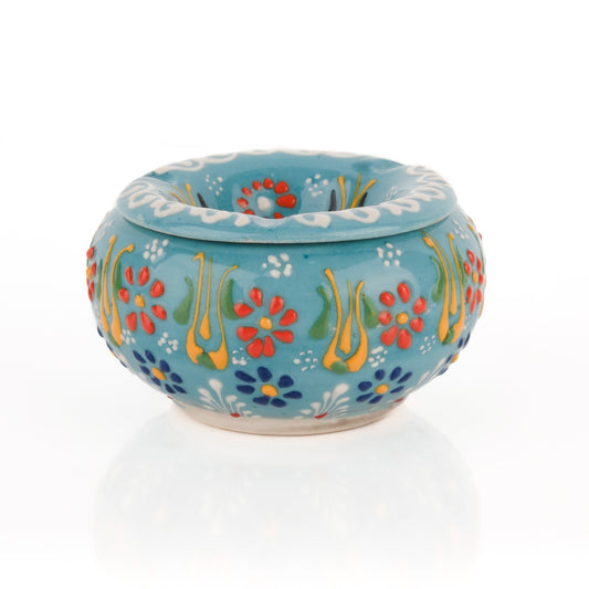 A handmade ceramic ashtray with a floral pattern in turquoise color, featuring a lid.
