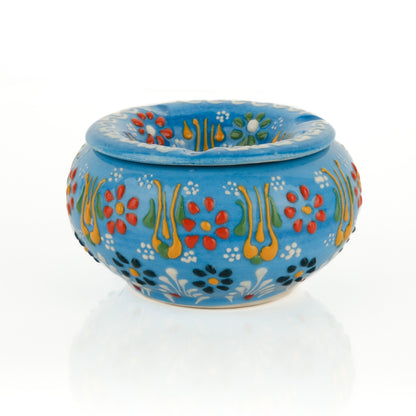 Decorative blue ceramic ashtray with colorful floral patterns on a white background