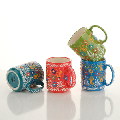 A set of colorful handcrafted ceramic mugs with floral and geometric patterns, displayed in a stacked arrangement.
