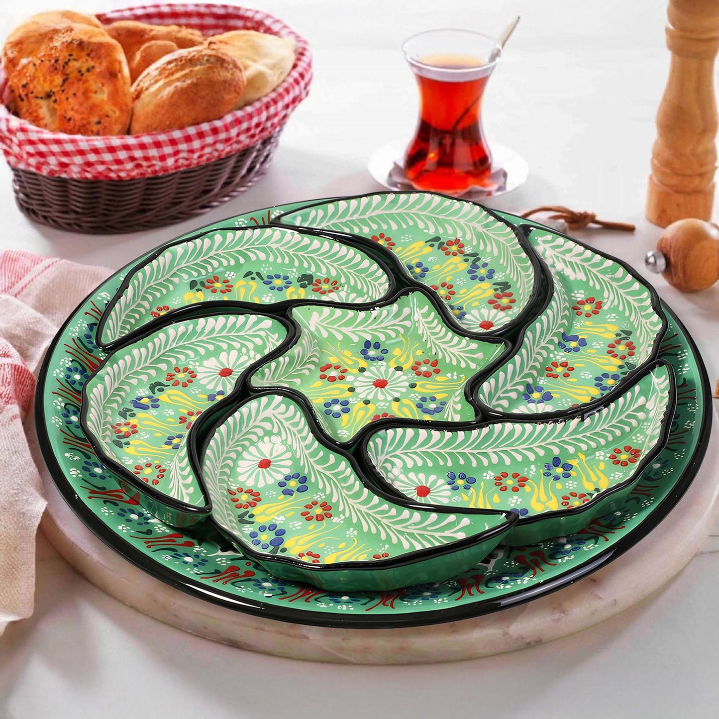 Decorative ceramic snack serving tray set with floral patterns on a table with bread and tea.