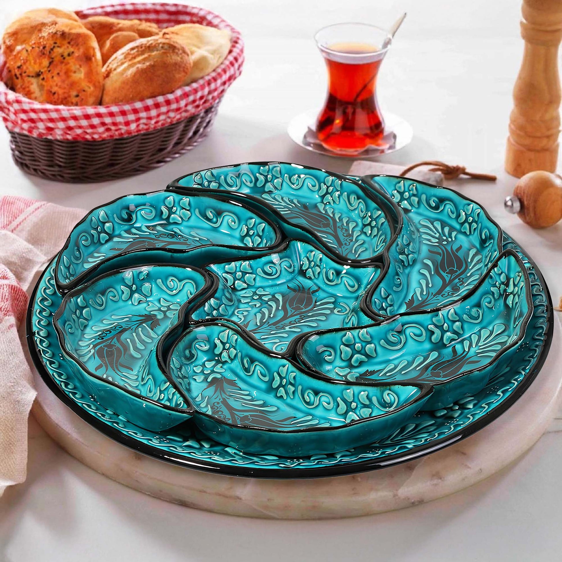 Turquoise ceramic snack serving tray set with decorative design on a table with bread and tea.