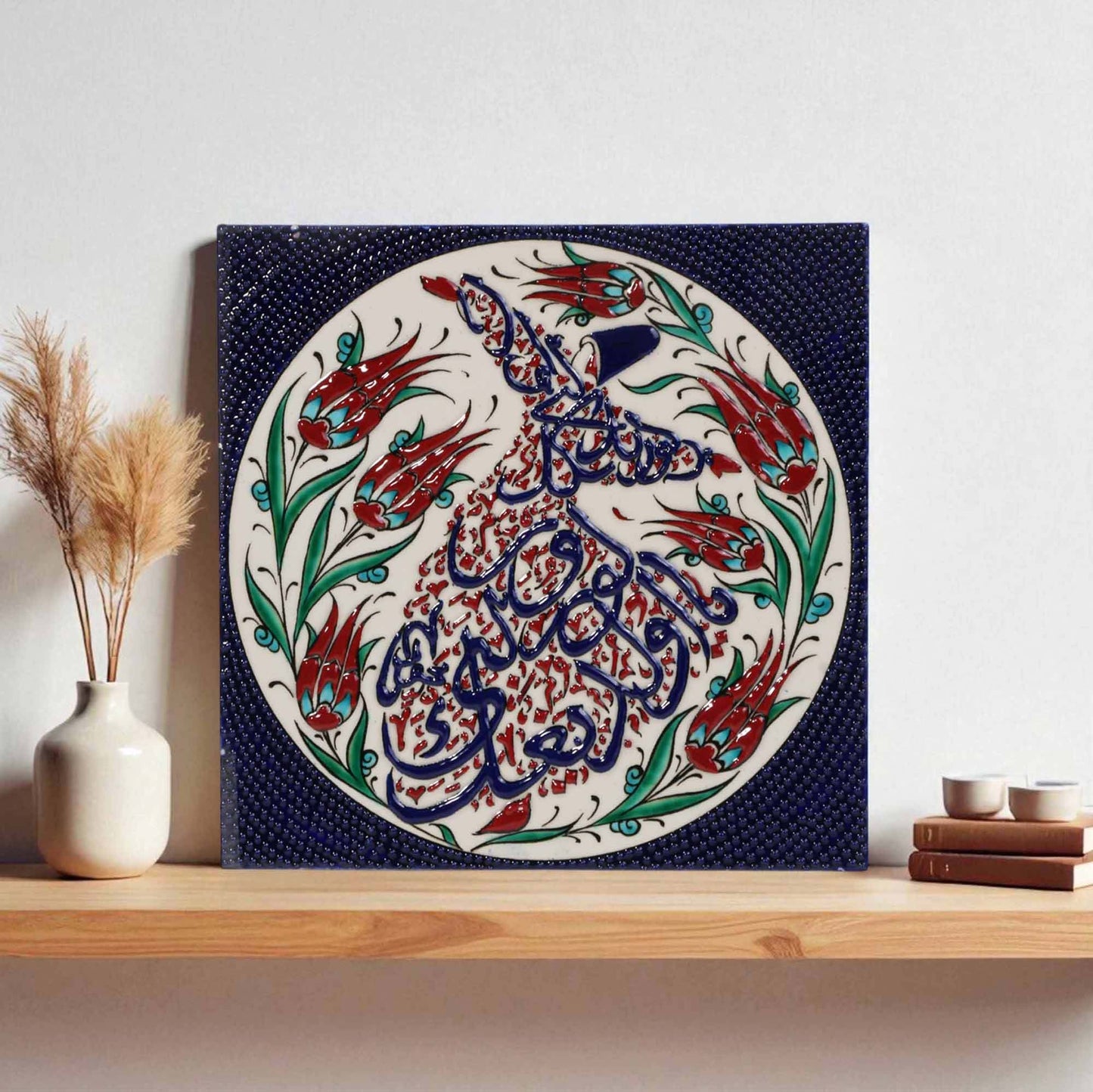 Decorative ceramic wall tile with intricate calligraphy and floral patterns on a shelf.