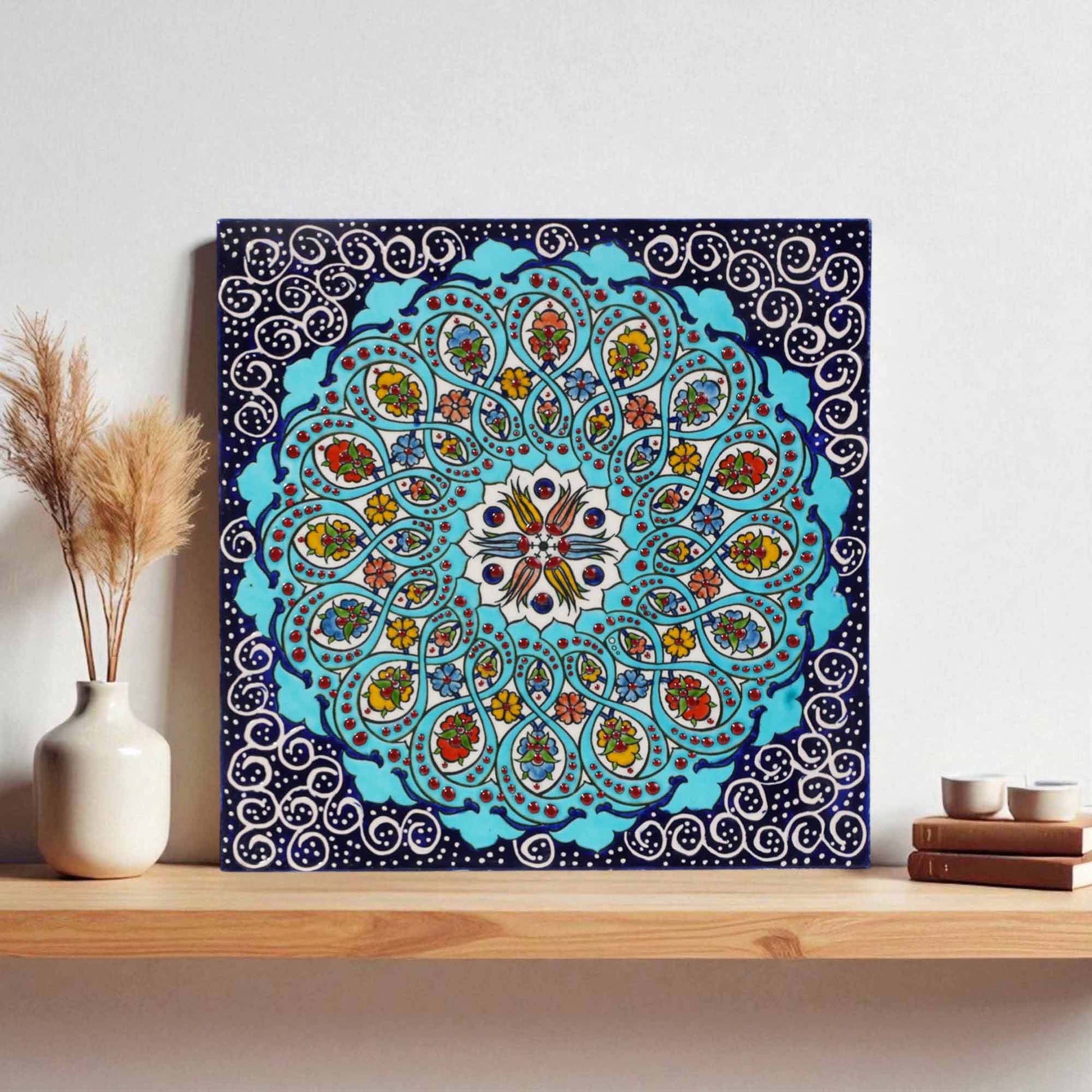 Decorative ceramic tile wall art with a colorful mandala design on a wooden shelf.