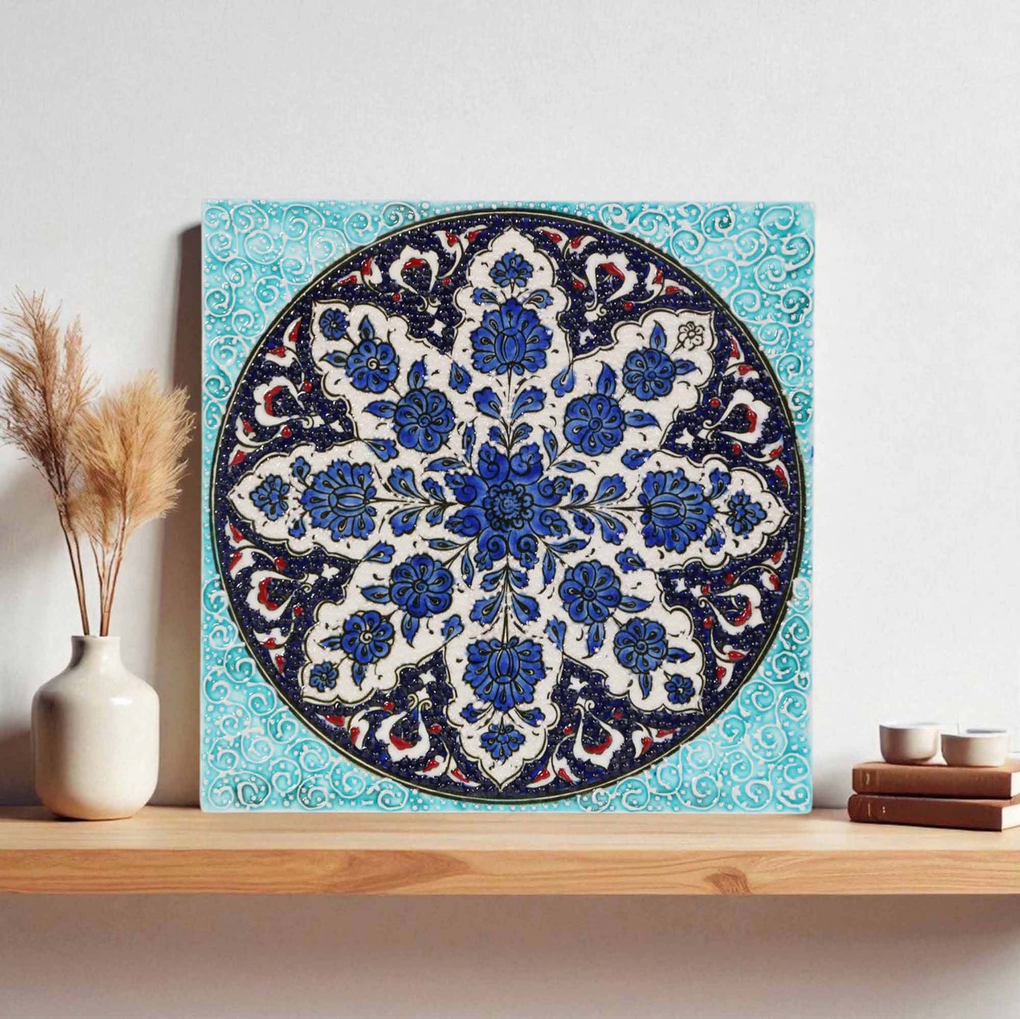 Decorative ceramic tile with floral pattern on a wooden shelf