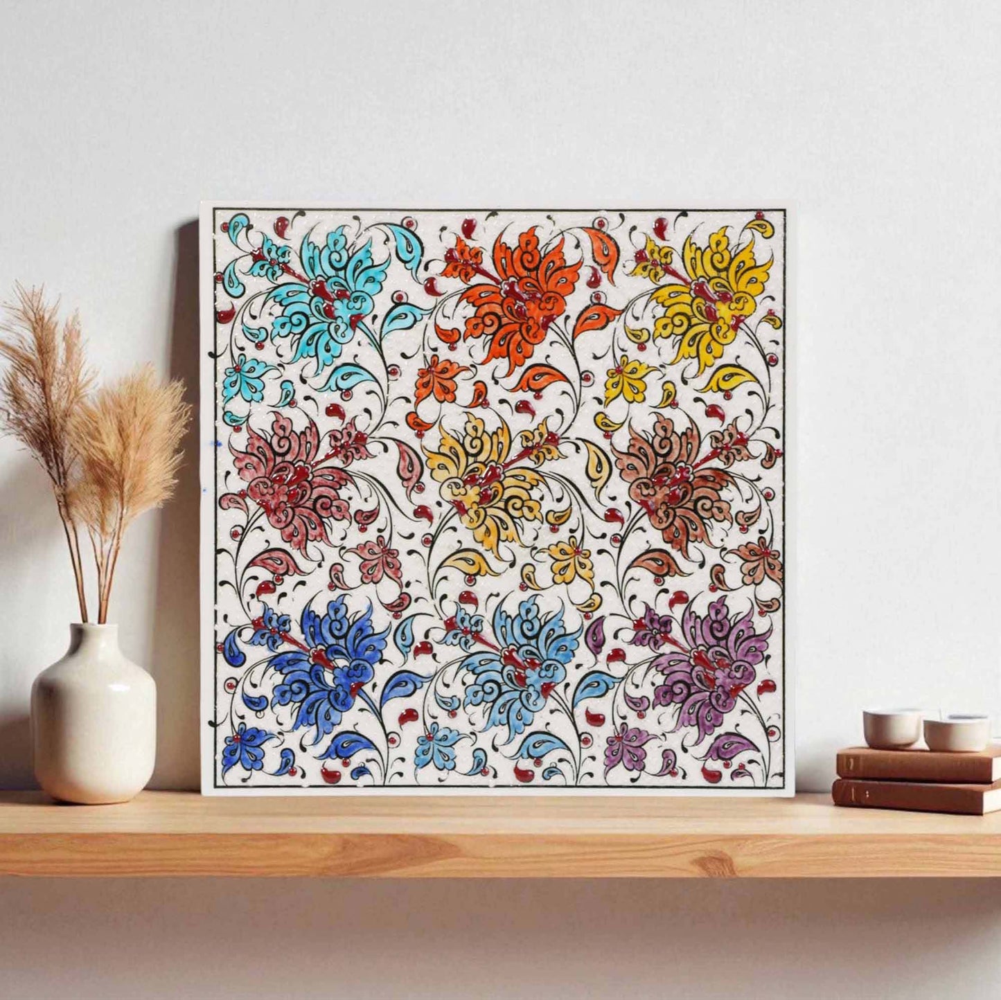 Framed floral ceramic tile on a wooden shelf with decorative items.