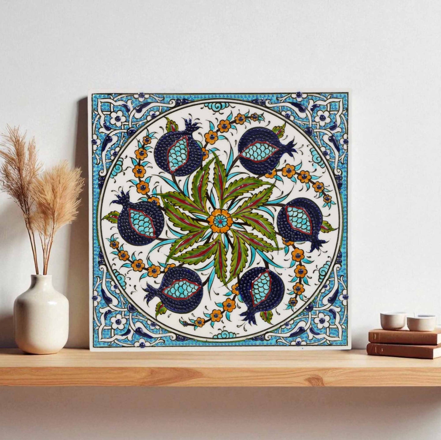 Decorative ceramic tile with floral and bird pattern on a wooden shelf
