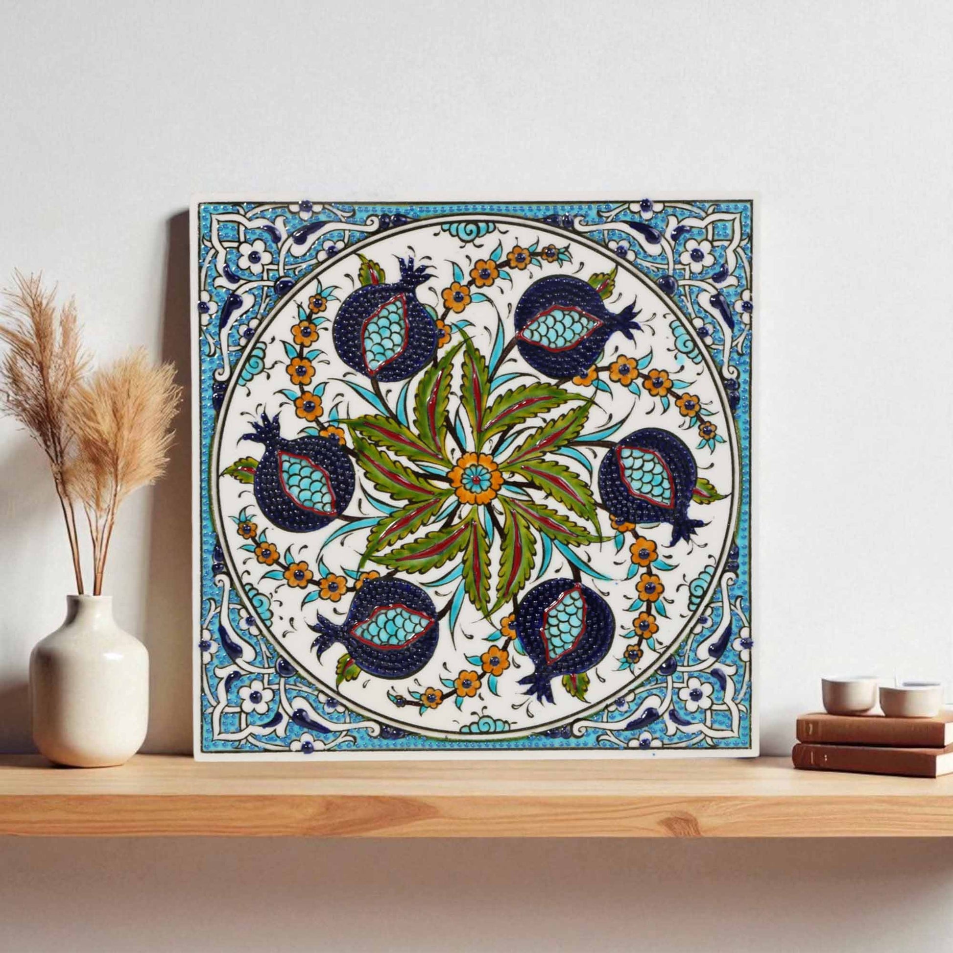 Decorative ceramic tile with floral and bird pattern on a wooden shelf