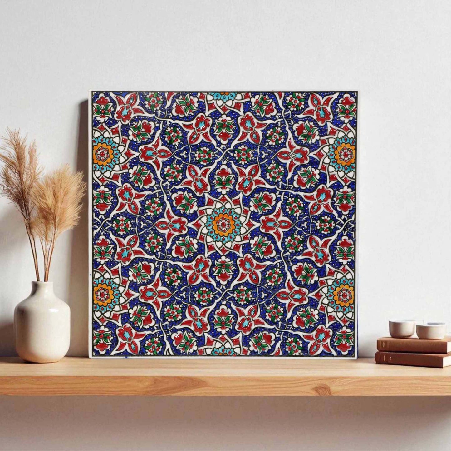 Decorative ceramic tile with floral pattern on a wooden shelf
