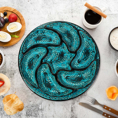 Decorative blue snack serving tray set with black floral patterns on a table with food items.