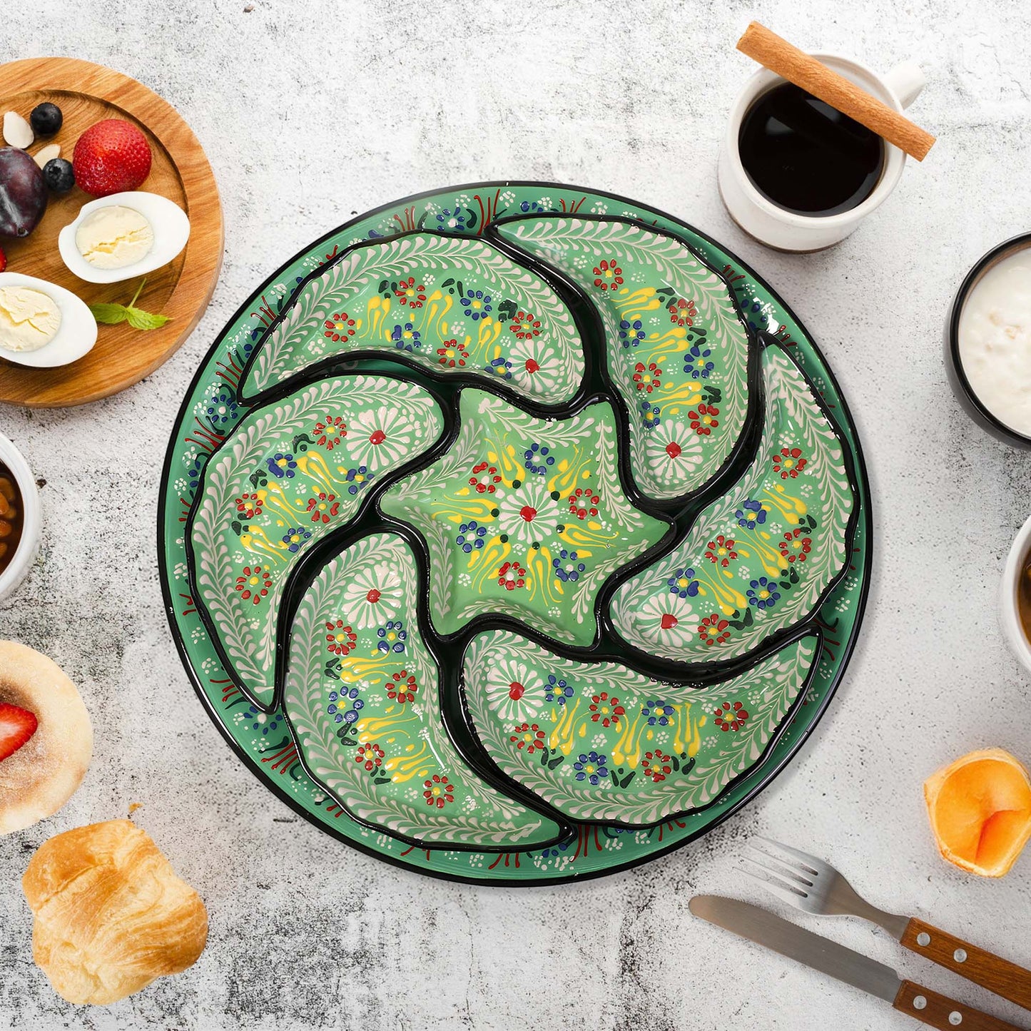 Decorative ceramic snack serving tray set with floral design on a table with food and coffee.