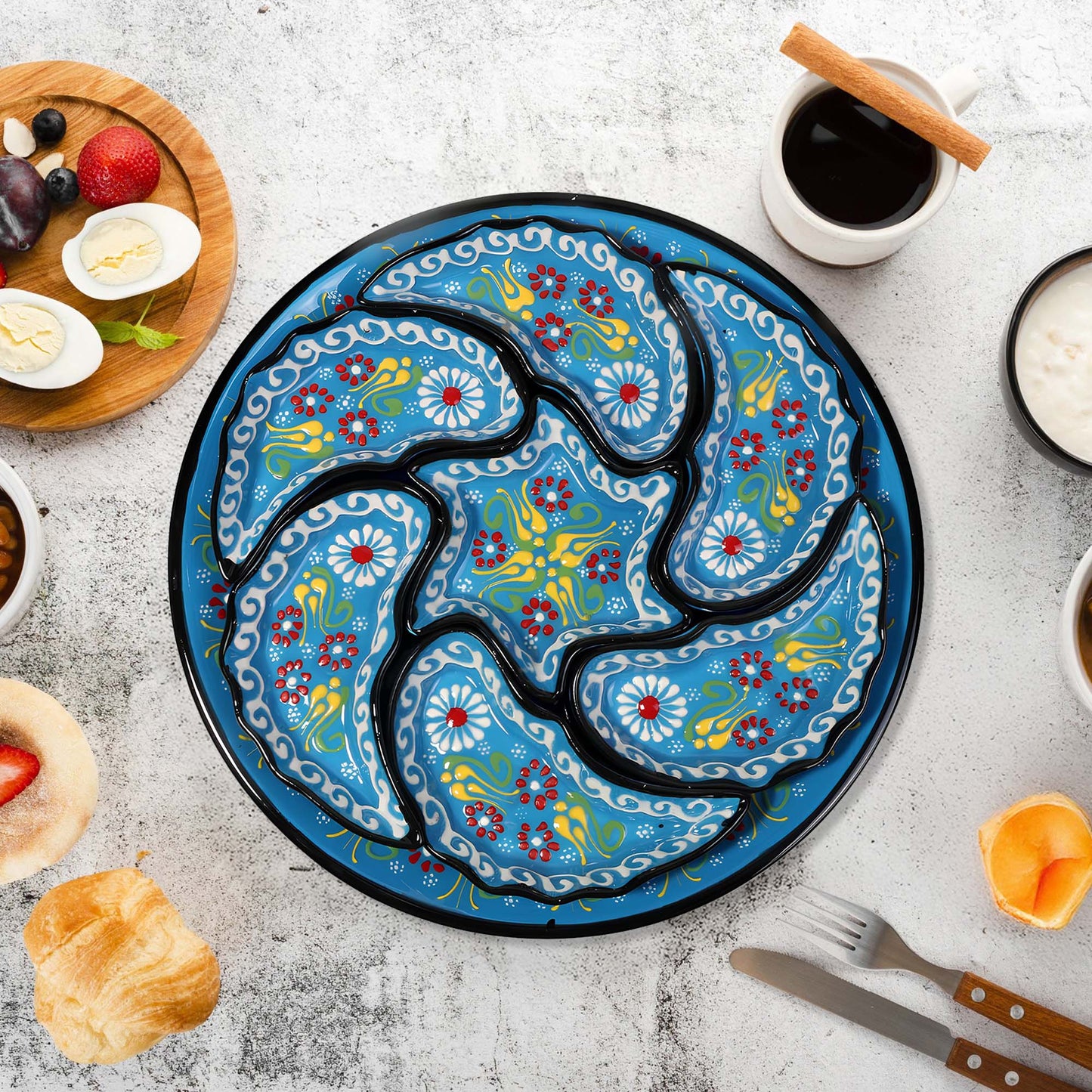 Decorative snack serving tray set with floral patterns on a table with food and coffee.