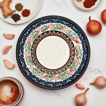 Decorative ceramic garlic grater bowl with intricate patterns on a white surface with ingredients.