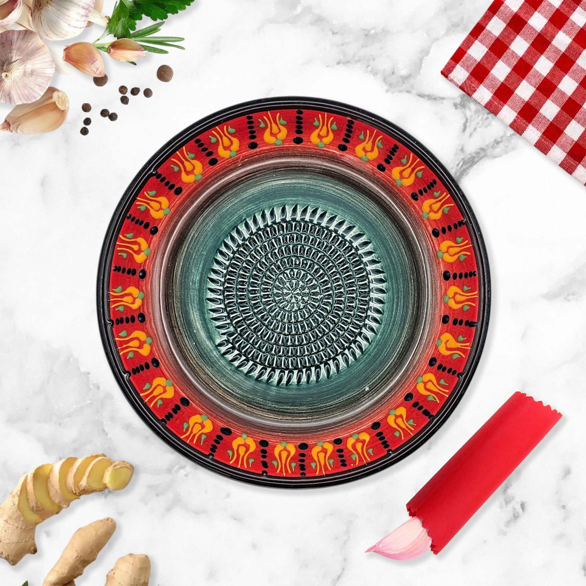 Decorative ceramic garlic grater bowl with colorful on a marble surface with kitchen items.
