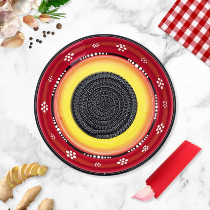 Decorative garlic grater bowl with a central circular design on a marble surface with kitchen items.
