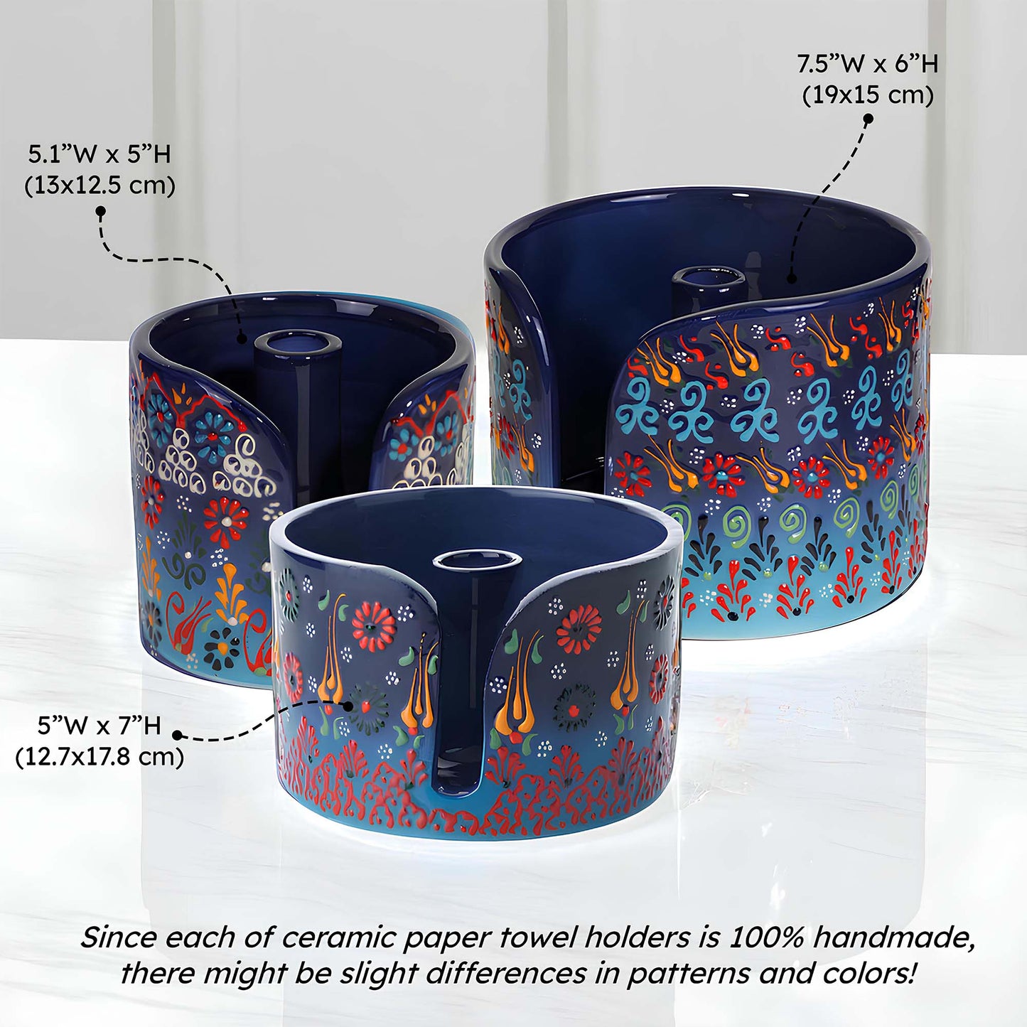Three ceramic paper towel holders with floral patterns on a white background