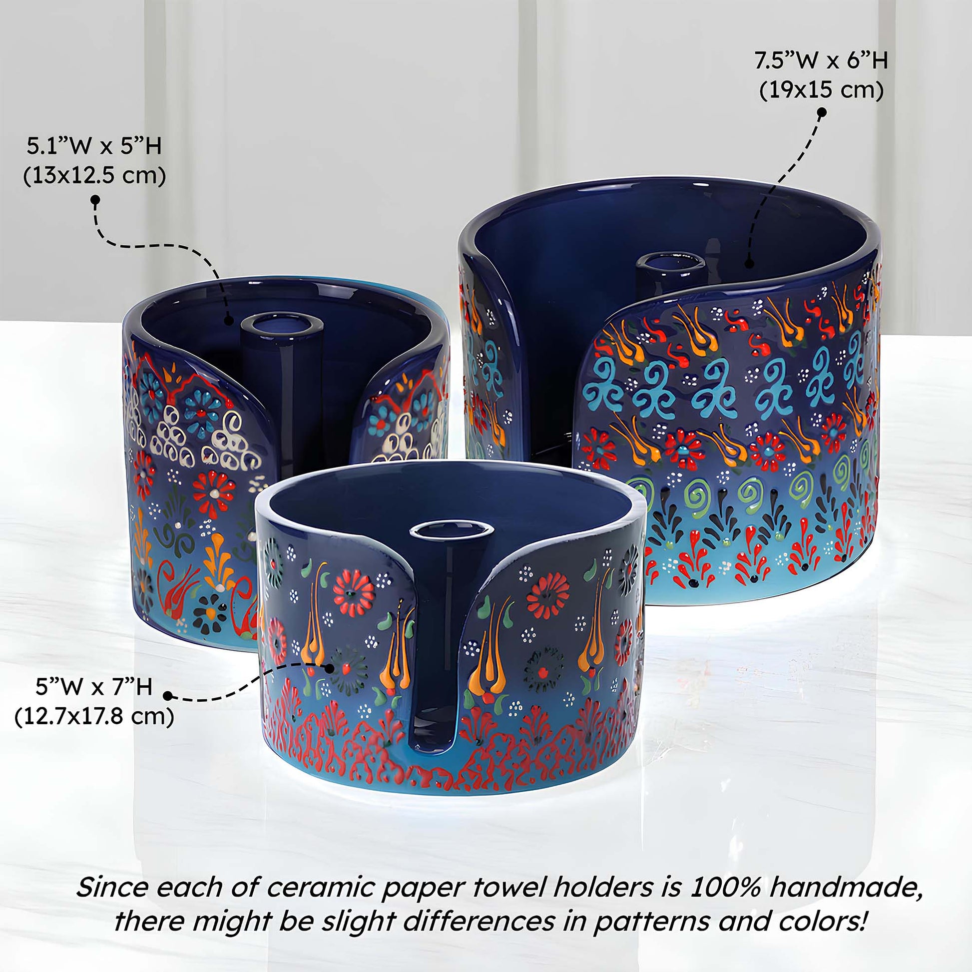 Three ceramic paper towel holders with floral patterns on a white background