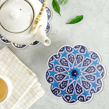 Decorative blue and white trivet with a teapot and cup on a light surface.