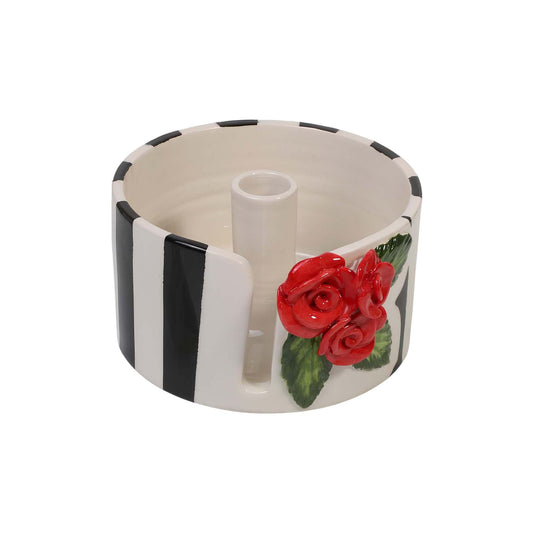 Ceramic paper towel holder with red roses and black and white design on a white background