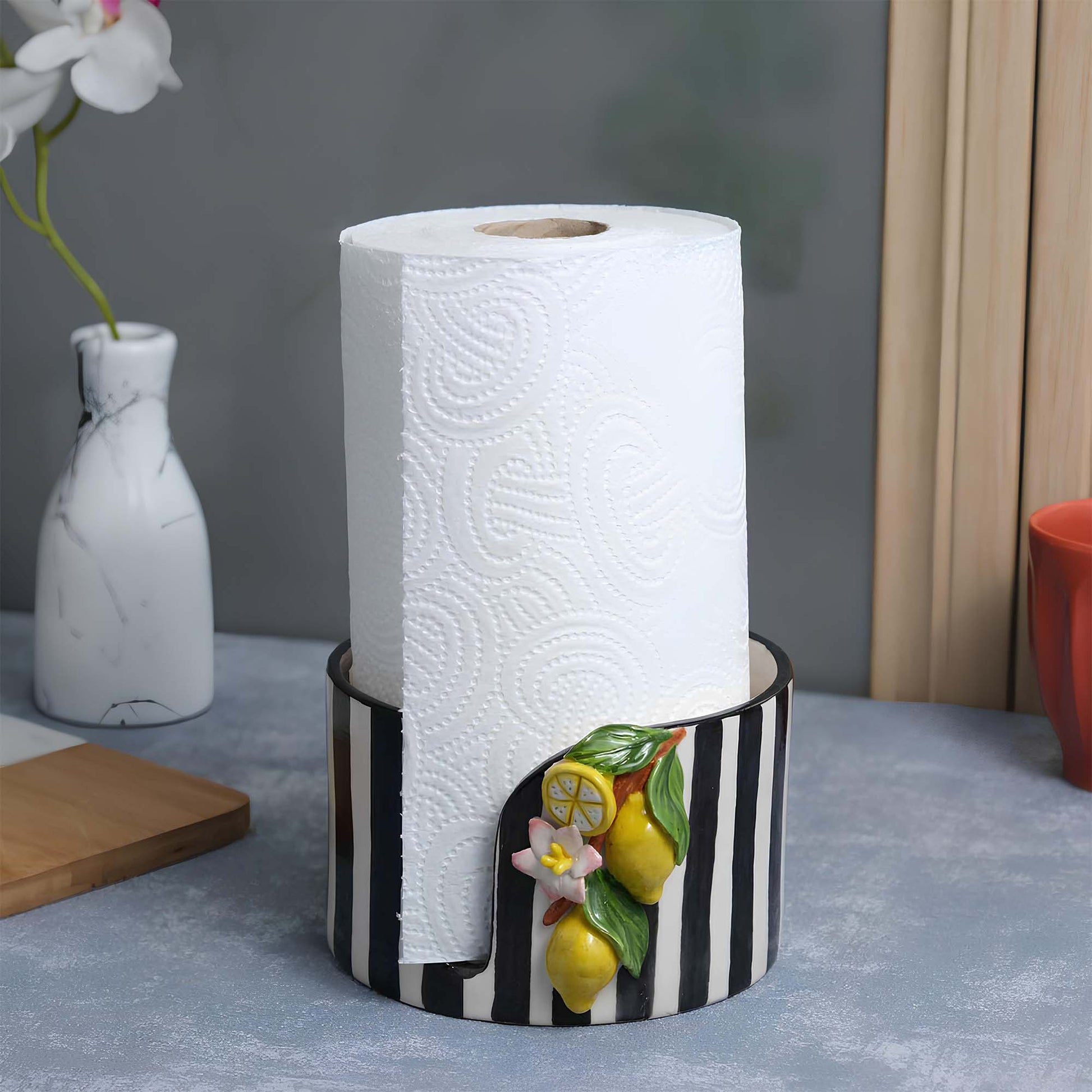 Decorative paper towel holder with lemons and flowers on a table
