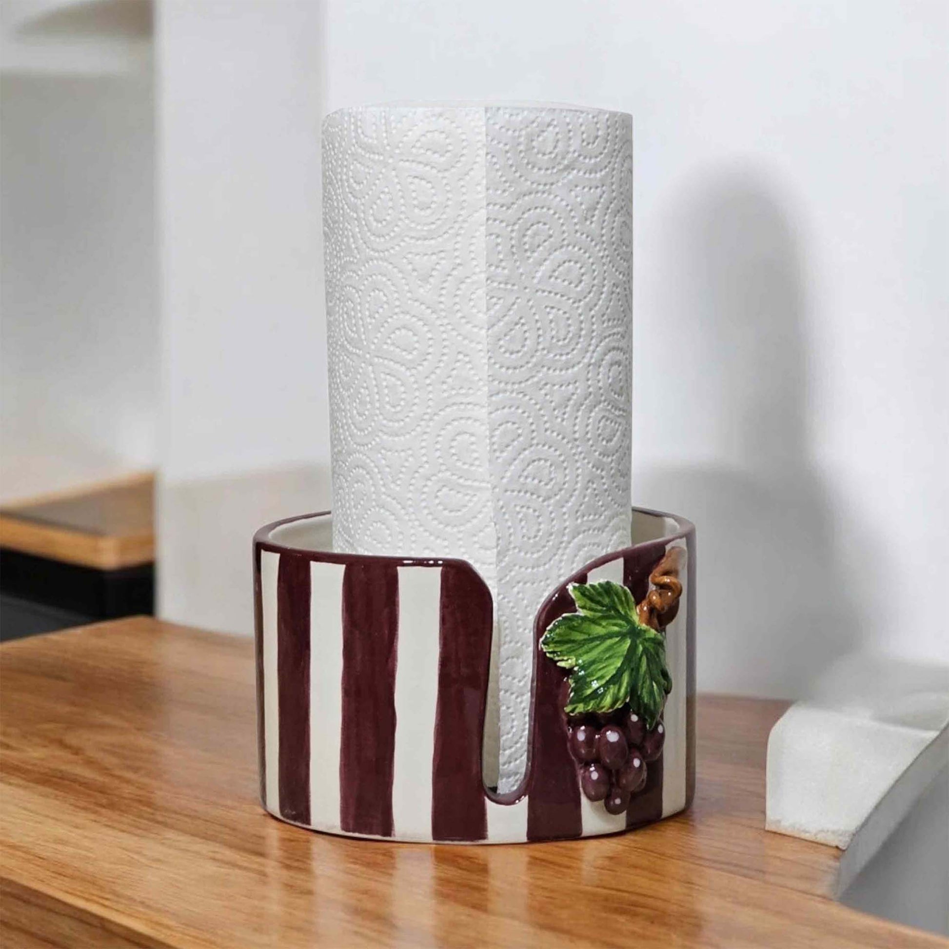 Ceramic paper towel holder with a decorative design on a wooden surface
