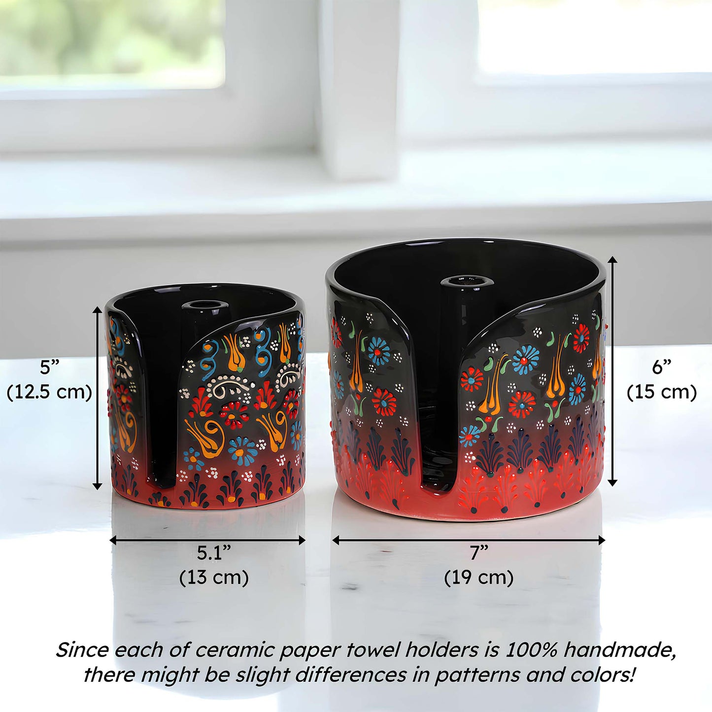 Two ceramic paper towel holders with floral designs and measurements on a white surface.