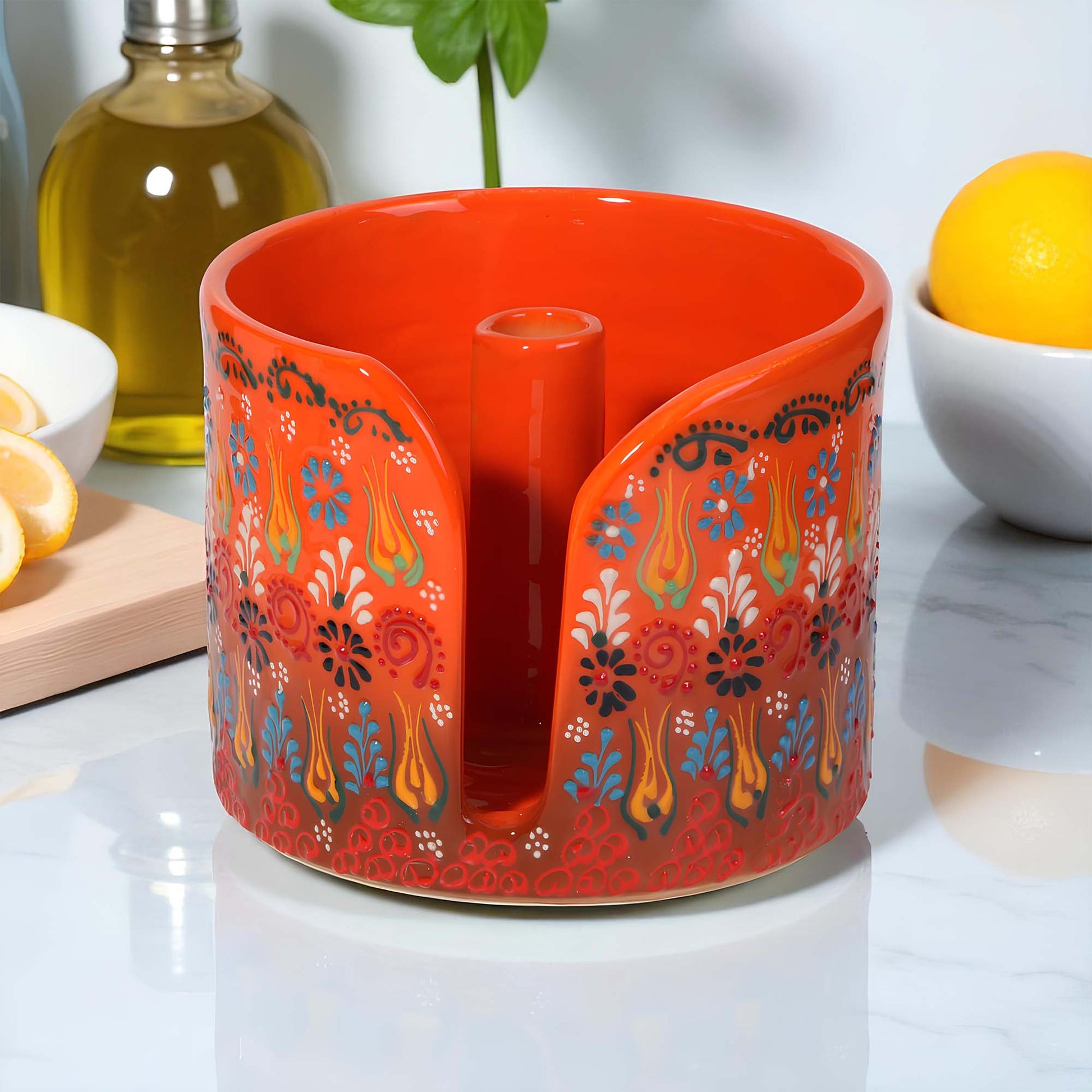 Decorative red paper towel holder  with floral patterns on a kitchen counter.