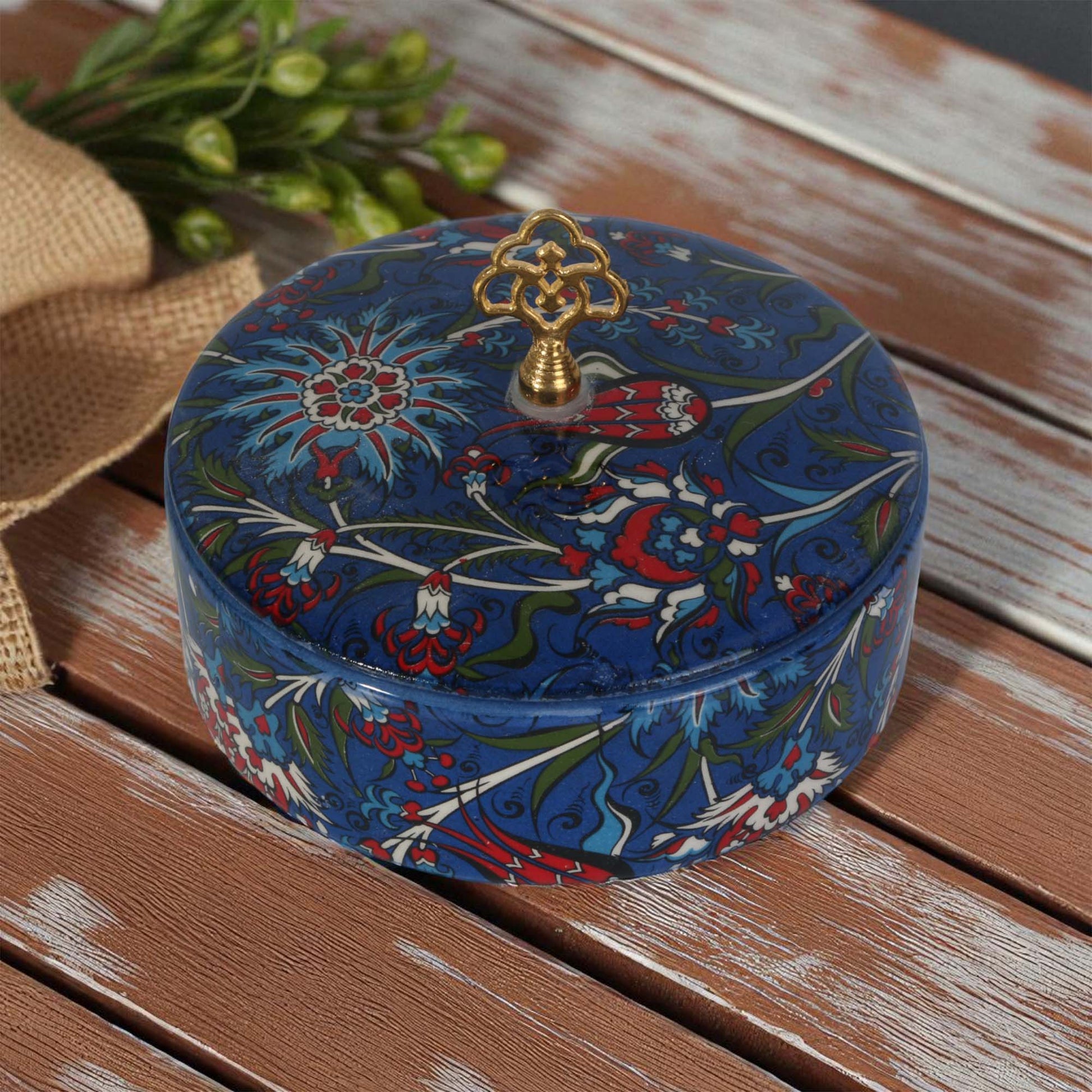 Decorative blue sugar bowl with floral patterns on a wooden surface