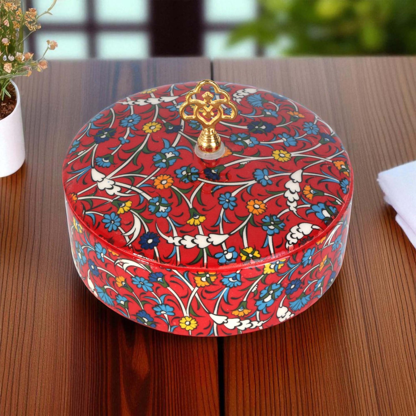 Decorative sugar bowl with floral pattern on a wooden surface