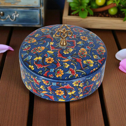 Decorative sugar bowl with floral patterns on a wooden surface