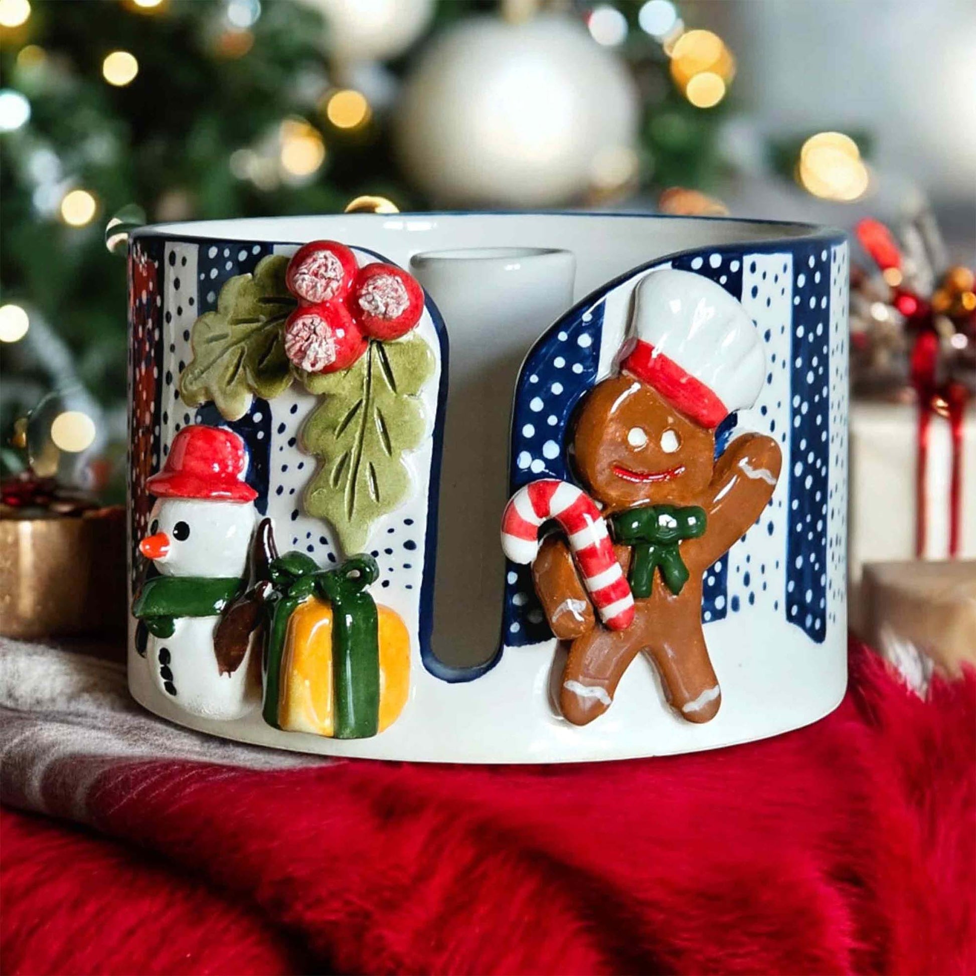 Decorative paper towel holder with Christmas-themed designs including a snowman, gingerbread man, and holly leaves.