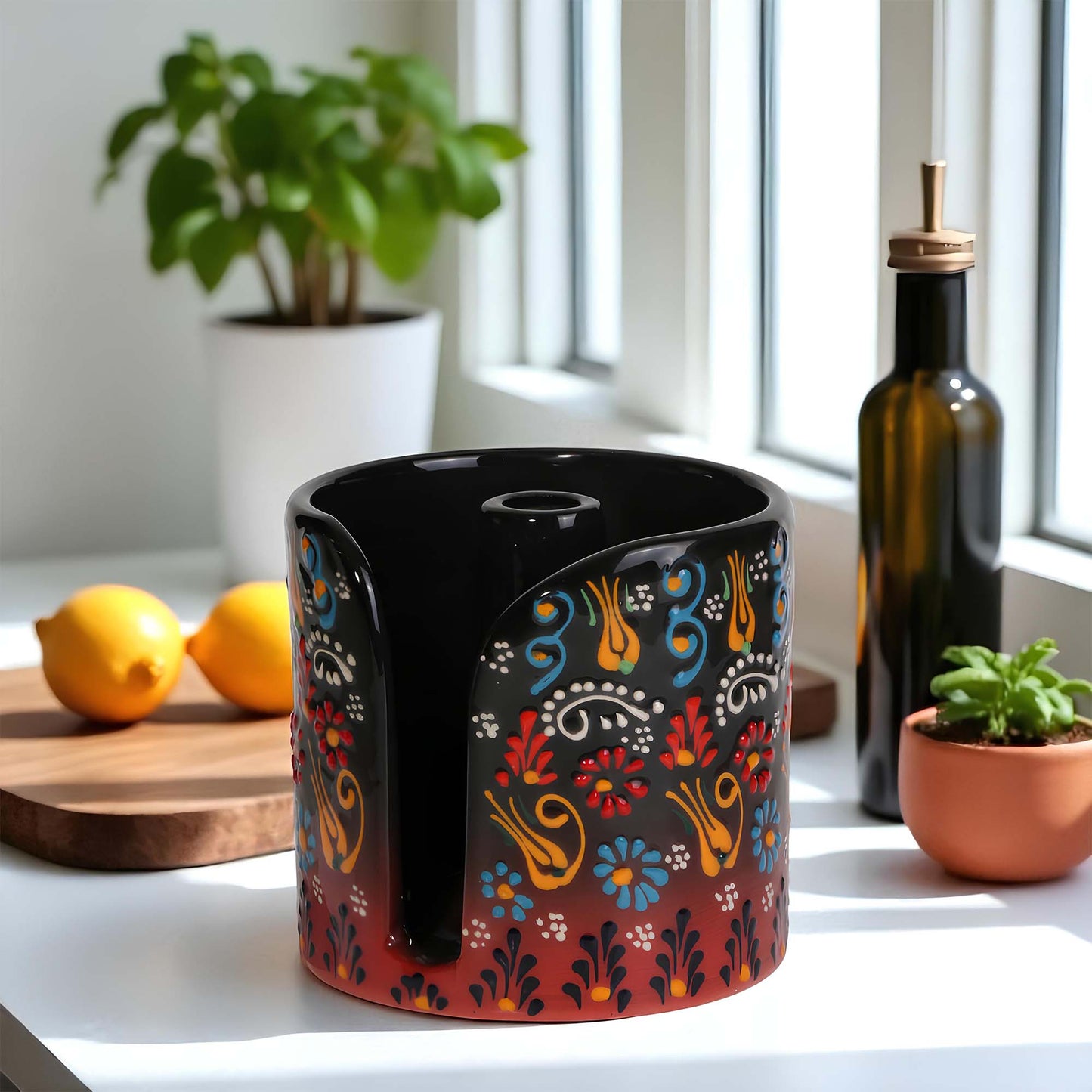 Decorative paper towel holder with colorful patterns on a kitchen counter with lemons and a bottle in the background.