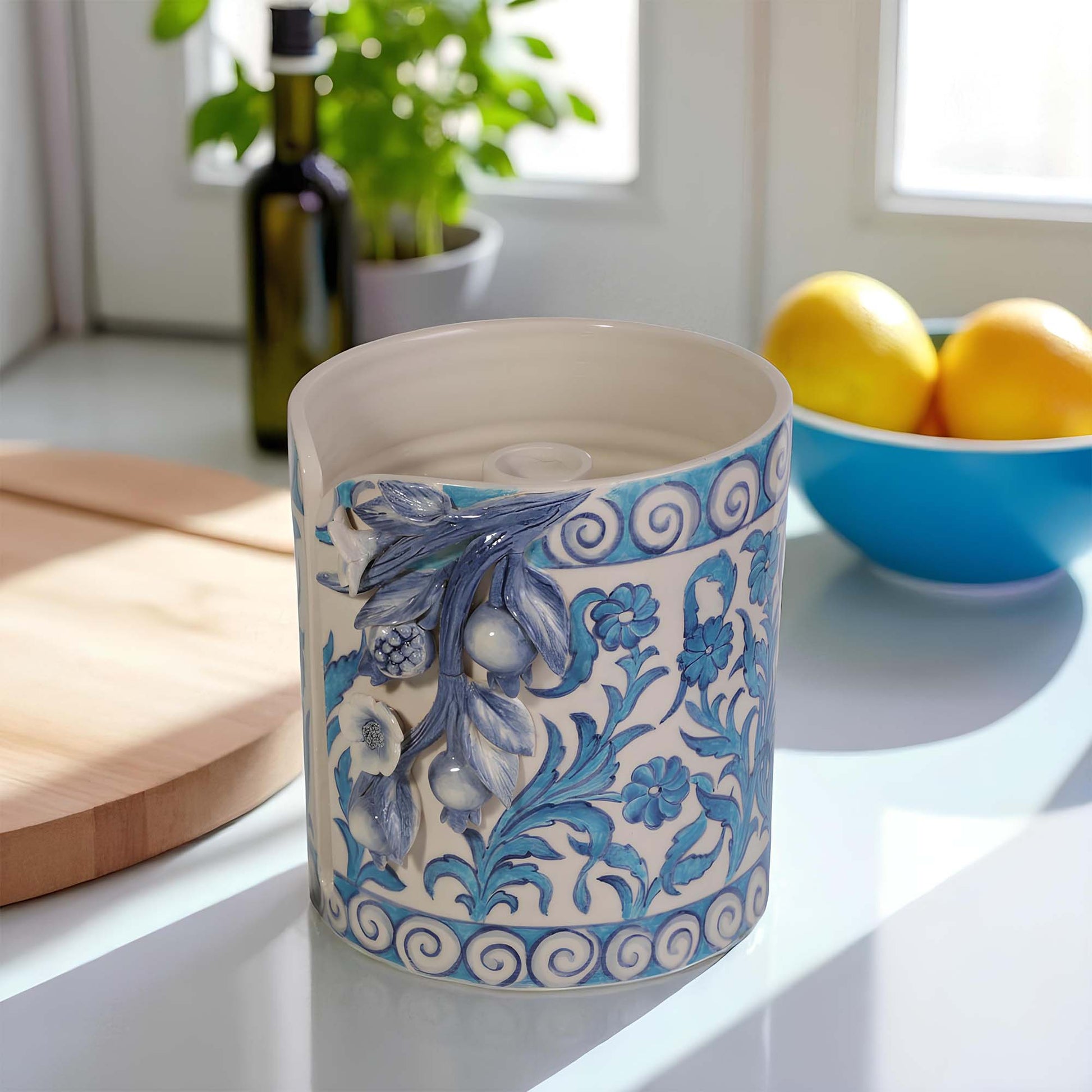 Decorative ceramic paper towel holder with blue floral patterns on a kitchen counter.