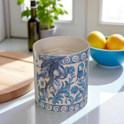Decorative ceramic paper towel holder with blue floral patterns on a kitchen counter.