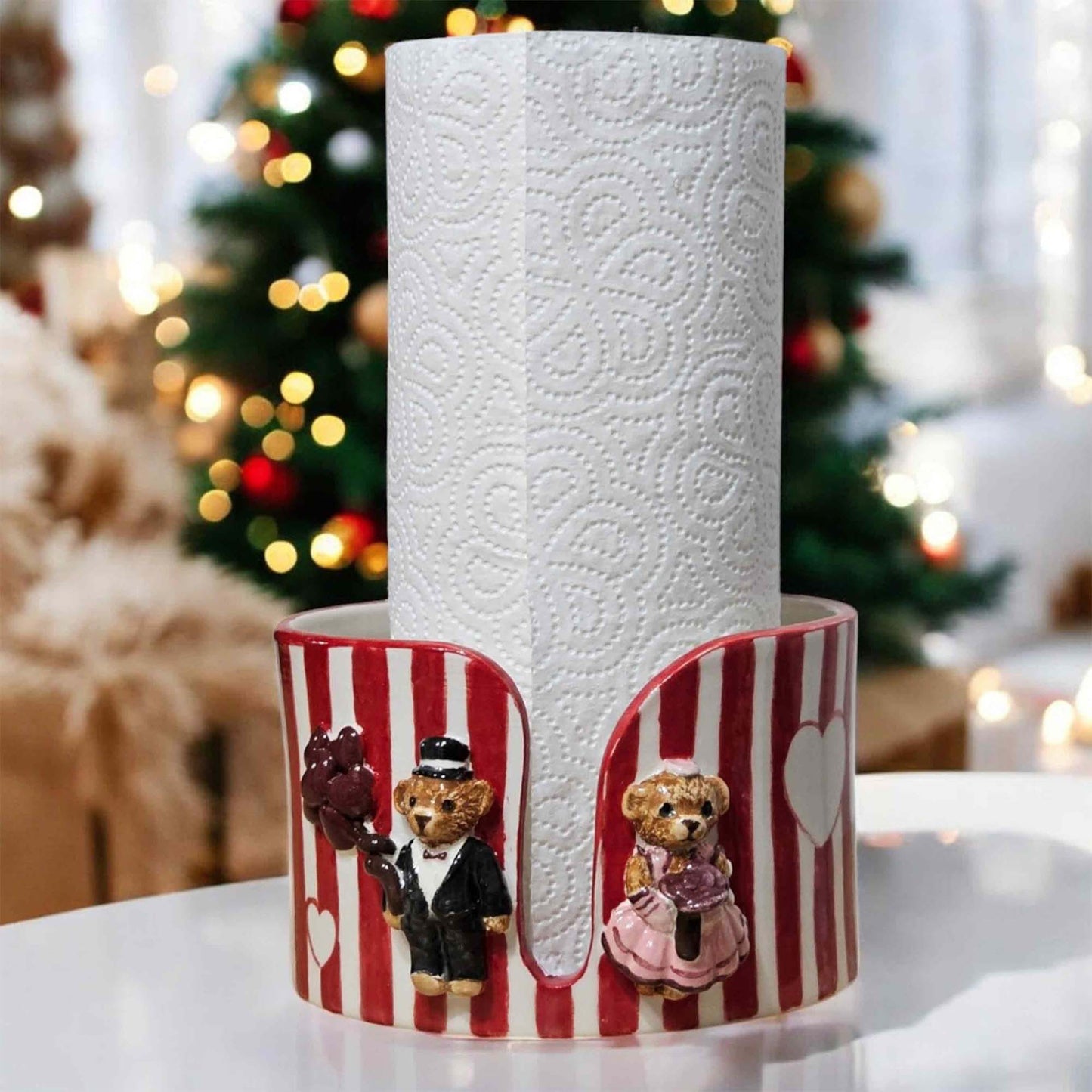 Decorative paper towel holder with teddy bears in front of a Christmas tree.