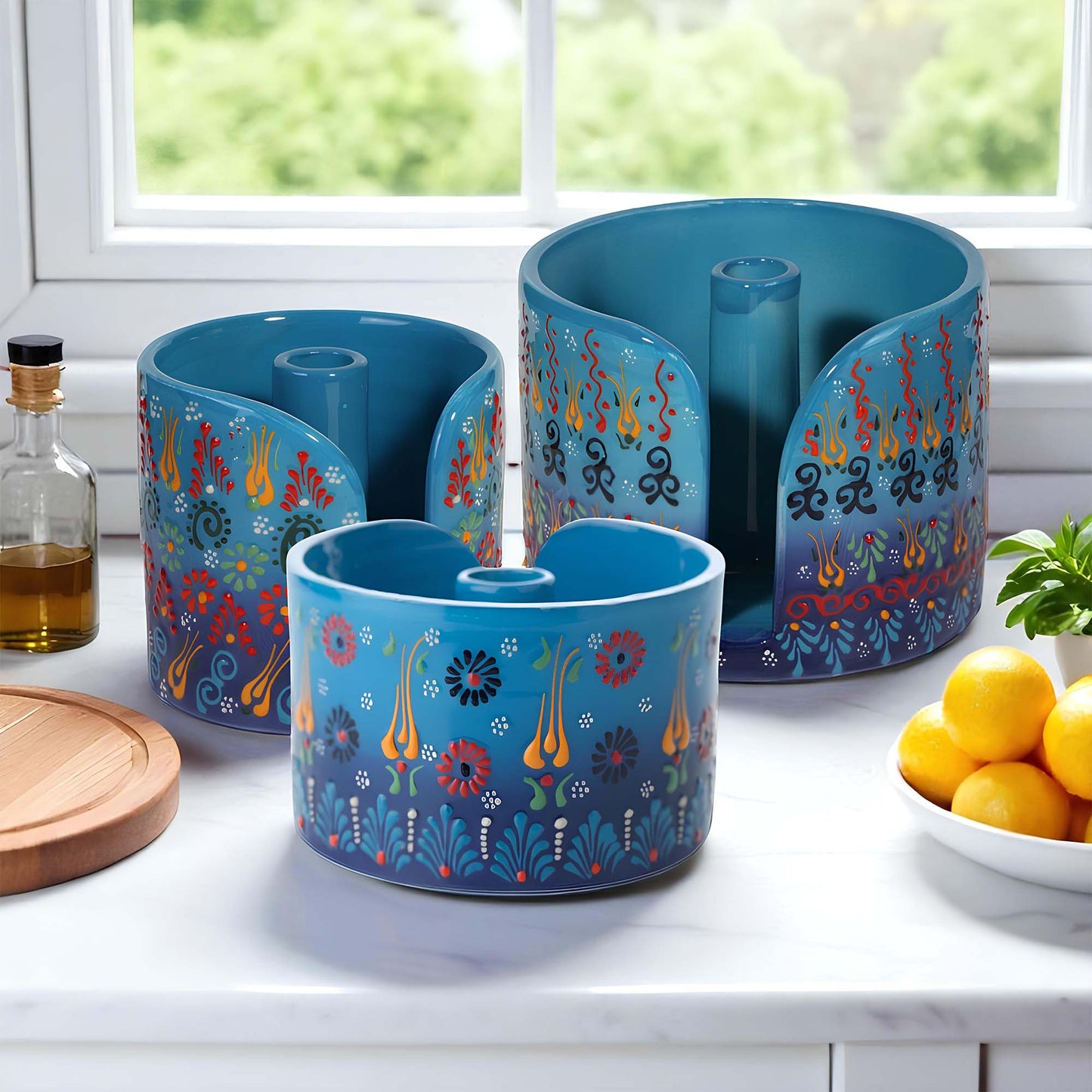 Set of blue paper towel holder with colorful designs on a kitchen counter.