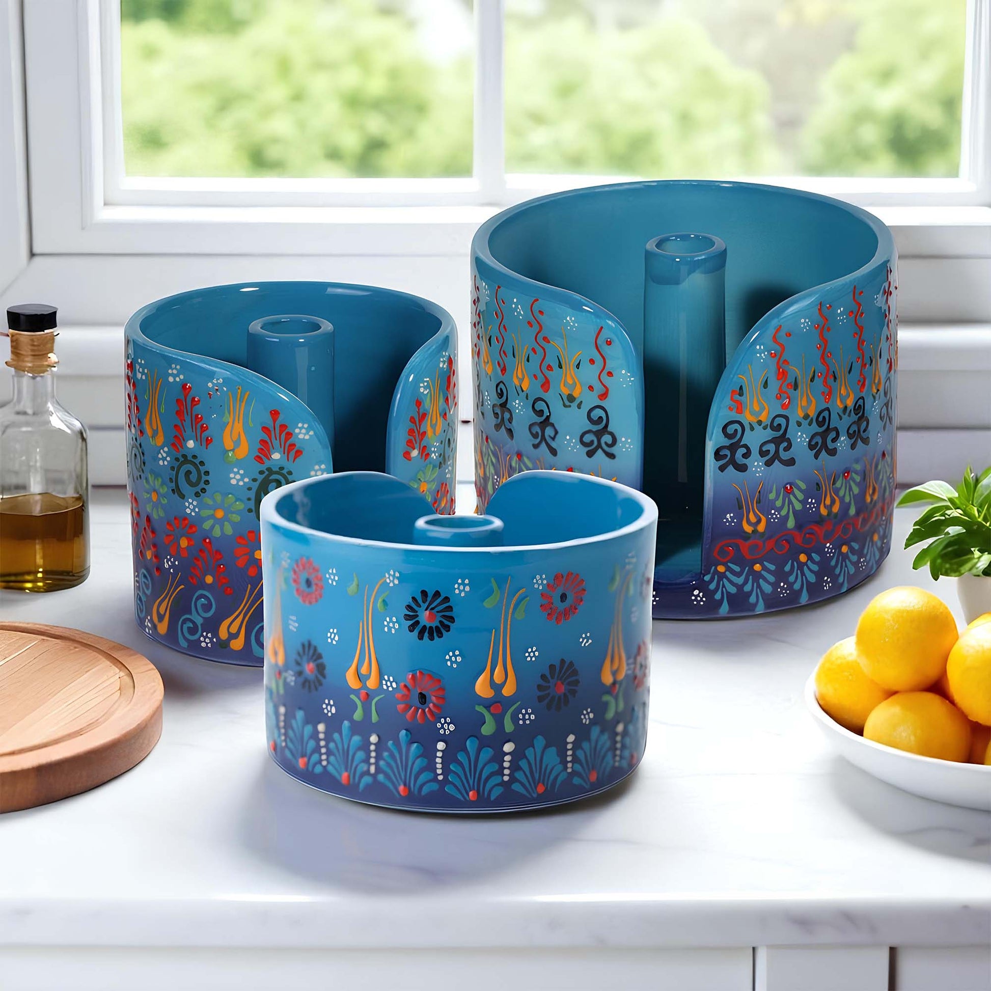 Set of blue paper towel holder with colorful designs on a kitchen counter.