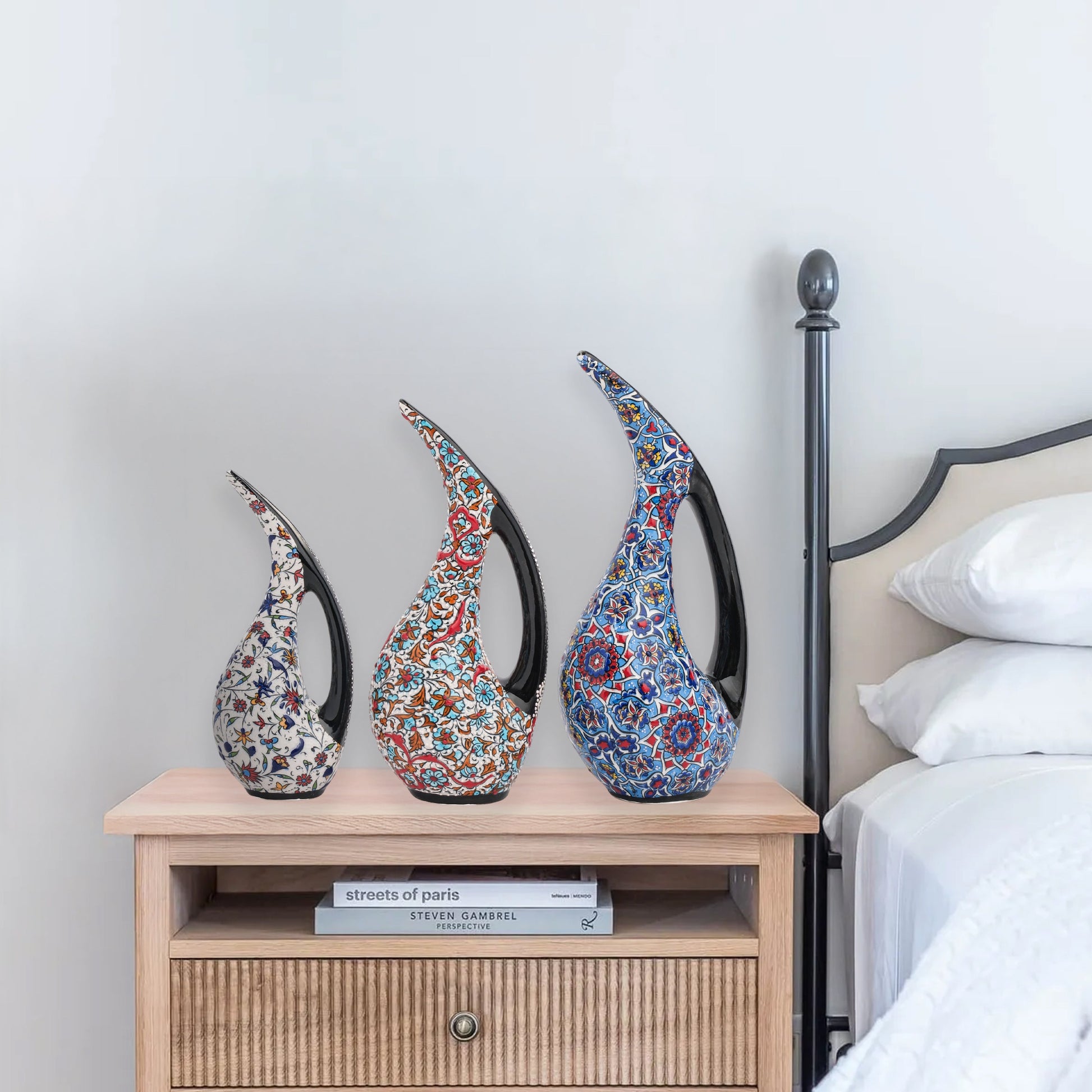 Set of 3 hand-painted ceramic ewers with Ottoman floral motifs in unique color palettes. Glossy artisan pieces with black handles, perfect décor or gifts.