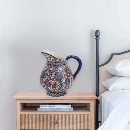 Hand-painted ceramic pitcher with Iznik-inspired tulips, carnations & leaves in red, blue & green. Decorative artisan piece, perfect for display.