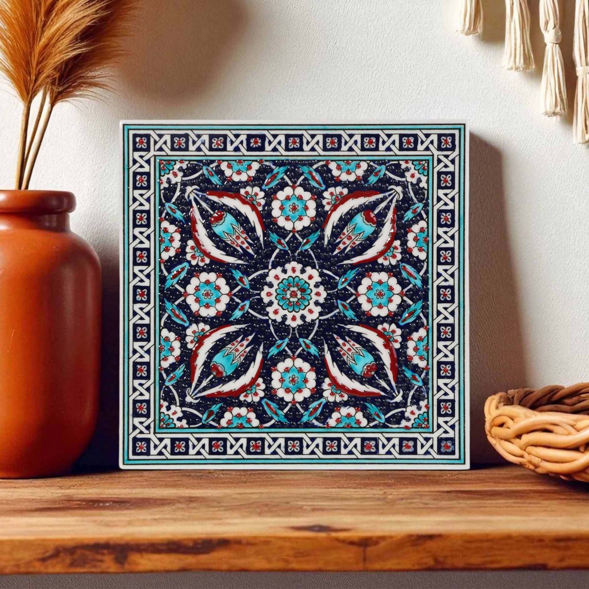 Decorative ceramic tile with floral pattern on a wooden shelf